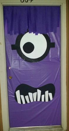 a door decorated with purple paper and black and white eyes, mouth, and teeth