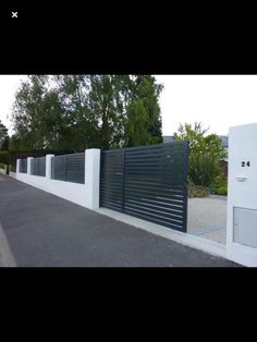 a black and white fence next to a road