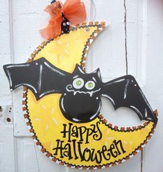 a halloween door hanger with a bat and moon on it