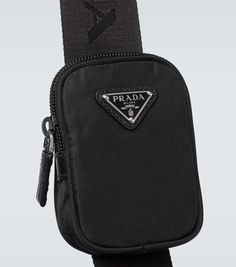 With an adjustable strap and small logo pouch, this black Prada bag is crafted from Re-Nylon, featuring a zipped top closure and triangle enamel logo on the front..Closure: zipped top.Internal details: fabric lining, internal pouch, internal zipped pocket, mobile phone pocket.Made in Italy.Material: fabric.Detachable, adjustable shoulder strap.Trim: calf leather.Height 46cm-18'.Width 41cm-16'.Min. length shoulder strap 92cm-36'.Max. length shoulder strap 112cm-44' Modern Black Shoulder Bag With Logo Plaque, Modern Black Bags With Logo Plaque, Black Crossbody Bag With Logo Plaque, Black Shoulder Bag With Logo Plaque For Business, Black Business Shoulder Bag With Logo Plaque, Black Shoulder Bag With Logo Plaque, Modern Travel Bags With Logo Plaque, Black Travel Bags With Logo Plaque, Luxury Black Bags With Logo Patch