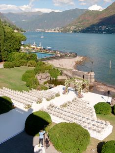 an aerial view of a wedding venue near the water with mountains in the back ground