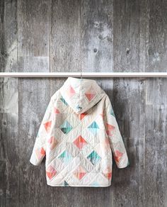 a white jacket hanging on a wooden wall