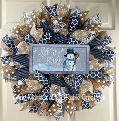 a snowman wreath on the front door with a sign that says let it snow