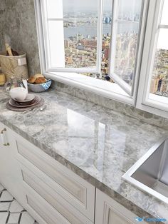 a marble counter top in a kitchen next to a window with the city skyline seen through it