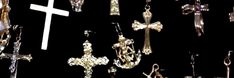 many different types of crosses hanging from hooks