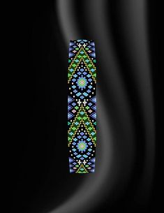 a black background with an abstract design in the center and blue, green, yellow, and white colors