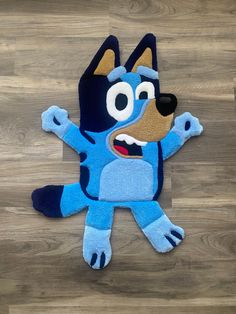 a blue rug with a cartoon dog on it's back and arms spread out