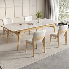 a dining room table with white chairs and a plant in the center on a rug