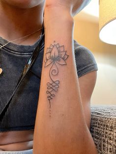 a woman's arm with a tattoo on it that has a flower in the middle