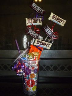 a glass filled with candy and hersheys on top of a table next to a microwave