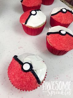 some red cupcakes with white frosting and black eyes