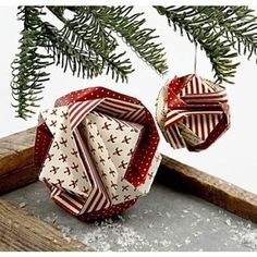 an ornament hanging from a tree branch with snow on the ground below it