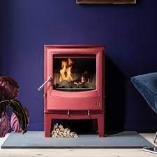 a red stove sitting next to a purple wall in a living room with blue walls