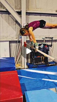 a woman is doing an acrobatic trick on the bars