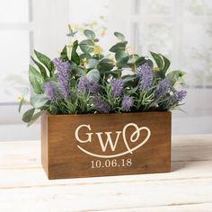 a wooden box filled with purple flowers and greenery