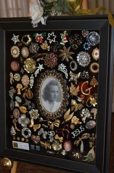 a black frame covered in lots of different types of brooches and other items