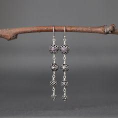 "Four gorgeous and detailed graduated Bali Silver beads are wire wrapped to create these gorgeous statement earrings. These dangle from balled silver earwires. Perfect dramatic earrings for anyone to wear everyday or save for a special occasion. First Bali Silver bead: 8mm Second Bali Silver bead: 7mm Third Bali Silver bead: 6mm Fourth Bali Silver bead: 5mm Total length of earrings: 2 3/8\" All silver is sterling. As the owner, maker, designer, and curator of this shop, I take great pride in pro Dangling Beads Drop Earrings, Sterling Silver Beaded Earrings For Jewelry Making, Elegant Silver Beaded Earrings Wire Wrapped, Elegant Silver Beaded Earrings With Wire Wrapping, Ear Wire Drop Earrings For Jewelry Making, Elegant Wire Wrapped Metal Linear Earrings, Elegant Nickel-free Chandelier Earrings With Round Beads, Sterling Silver Drop Cluster Earrings For Pierced Ears, Sterling Silver Drop Cluster Earrings