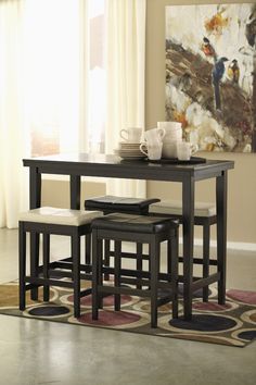 a dining room table and chairs with a rug