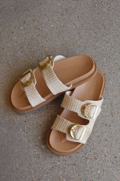 DETAILS: Our Tayo Slide in Natural Raffia is a luxe everyday slide. Complete any off-duty look with this contemporary luxe slide. These slides feature a flat footbed with a open round toe with chunky exposed sole. There are thick twin straps on upsper with adjustable buckle fastening. They have statement chunky buckle in gold hardware and an open heel counter made of synthetic upper, lining and outsole. These slides will be perfect to pair with any outfit this spring and summer! Woven Straw Slides For The Beach, Straw Slip-on Slides For Beach, Natural Woven Beach Slides, Beige Textured Slide Sandals, Beach Woven Slip-on Slides, Contemporary Luxe, Summer Slides, Summer Slide, Open Toed Heels