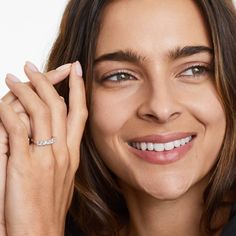 a woman smiling and wearing a diamond ring