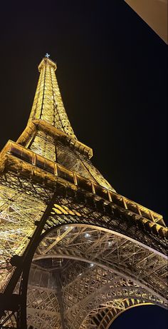 the eiffel tower lit up at night with lights on it's sides