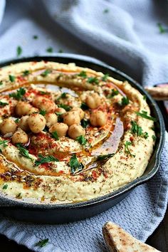 hummus in a skillet with garnishes and parsley on top