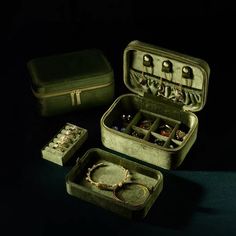 an open green suitcase with jewelry in it