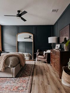 a bedroom with black walls and wooden floors