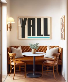 a living room with a couch, table and chairs in front of a large painting