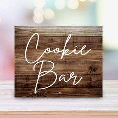 a wooden sign with the words cookie bar written in white ink on top of it