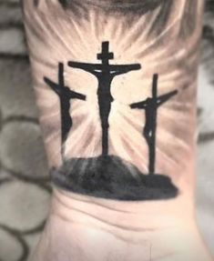 a person with a cross tattoo on their arm and the sun shining behind them,