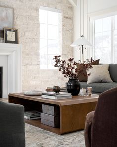 a living room with two couches and a coffee table in front of a fireplace