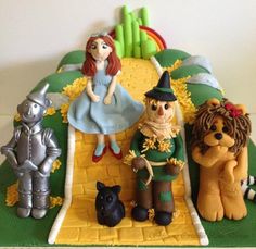 a birthday cake with wizard and lion figurines