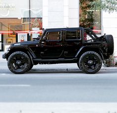 a black jeep is parked on the street