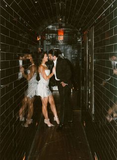 a man and woman are dancing in a tunnel