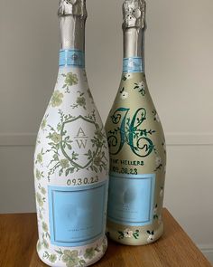 two decorative bottles sitting on top of a wooden table