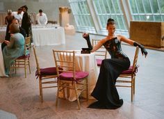 a woman sitting at a table in a room with many tables and chairs around her