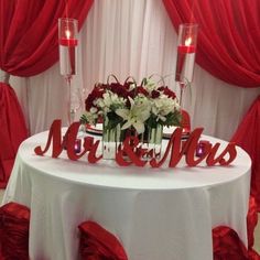 a white table topped with red and white flowers