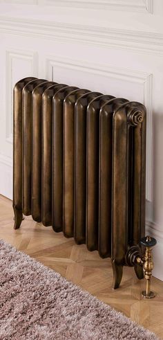 an antique style radiator in the corner of a room with a rug on the floor