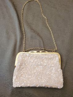 I purchased this vintage beaded clutch purse in the 1960's as I was going to Military Balls, Convention Awards Dinners, New Year's Eve and other formal events.  The purse has white pearls and sequins with a gold clasp and chain, which can be used as a shoulder bag.  Measuring 8x6x2 inches, the chain measures approximately 12 inches.  Cream is the color of the material used to line the clutch and on which the beads and sequins were attached.  A very pretty bag to set off your fanciest outfit. Elegant Beaded Evening Bag For Vintage Events, Formal Beaded Cream Evening Bag, Elegant White Evening Bag For Vintage Events, Formal Cream Beaded Evening Bag, Cream Beaded Clutch For Evening, Vintage Evening Bag With Pearl Embroidery For Events, Vintage Formal Evening Bag With Sequins, Cream Beaded Evening Bag, Formal Vintage Evening Bag With Pearl Handle