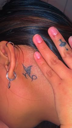 a woman with a cross tattoo on her ear