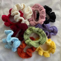 six crocheted scrunffles are laid out on a white sheet,