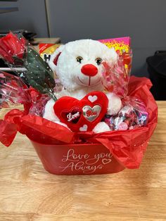 a white teddy bear sitting in a valentine's basket