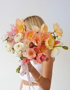 a woman holding a bouquet of flowers in her hands