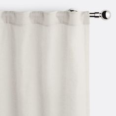 a white curtain hanging on the side of a window with an eyelet in front of it