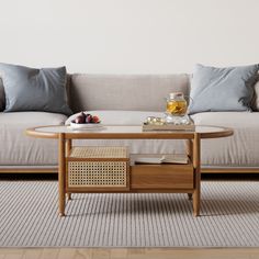 a coffee table sitting on top of a rug in front of a couch with pillows