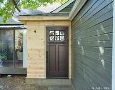 a small house with a brown door and side walk way to the front entrance area