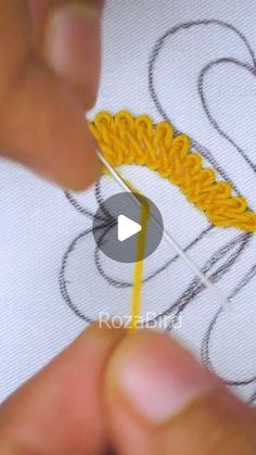 someone is stitching something with yellow thread