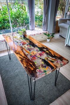 the table is made out of wood and has many different colored paint on it's surface