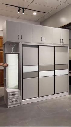 a man is standing in front of some cabinets